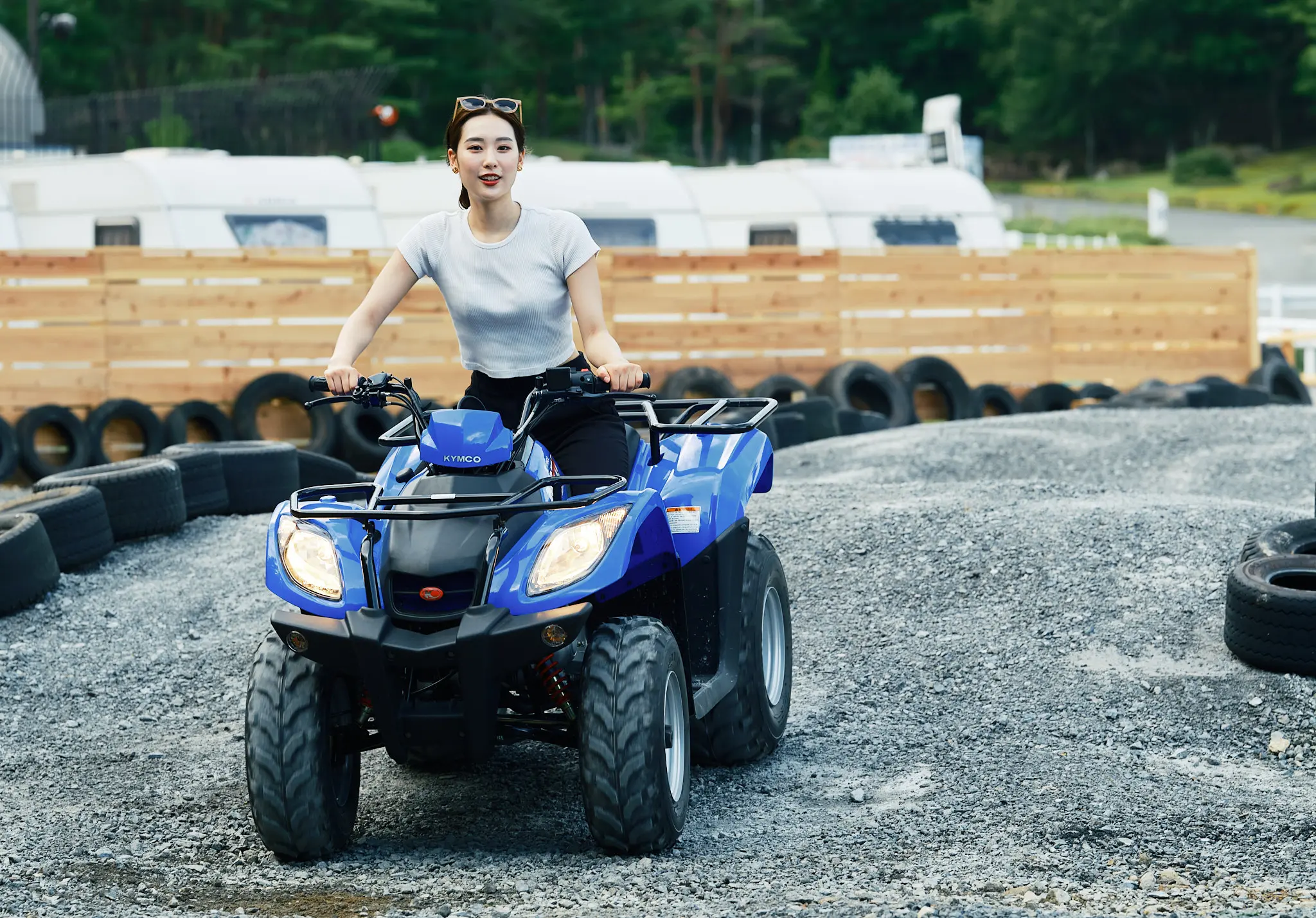 青いバギーに乗って笑顔を見せる女性